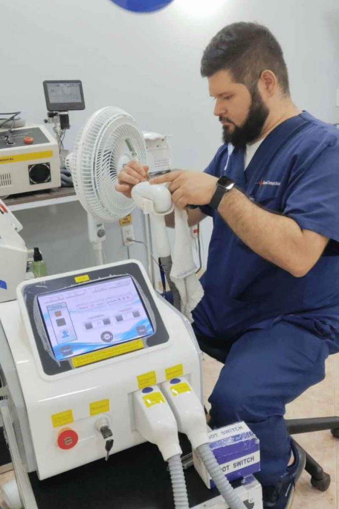 Ingeniero biomédico inspeccionando un equipo médico-estético durante un mantenimiento preventivo.